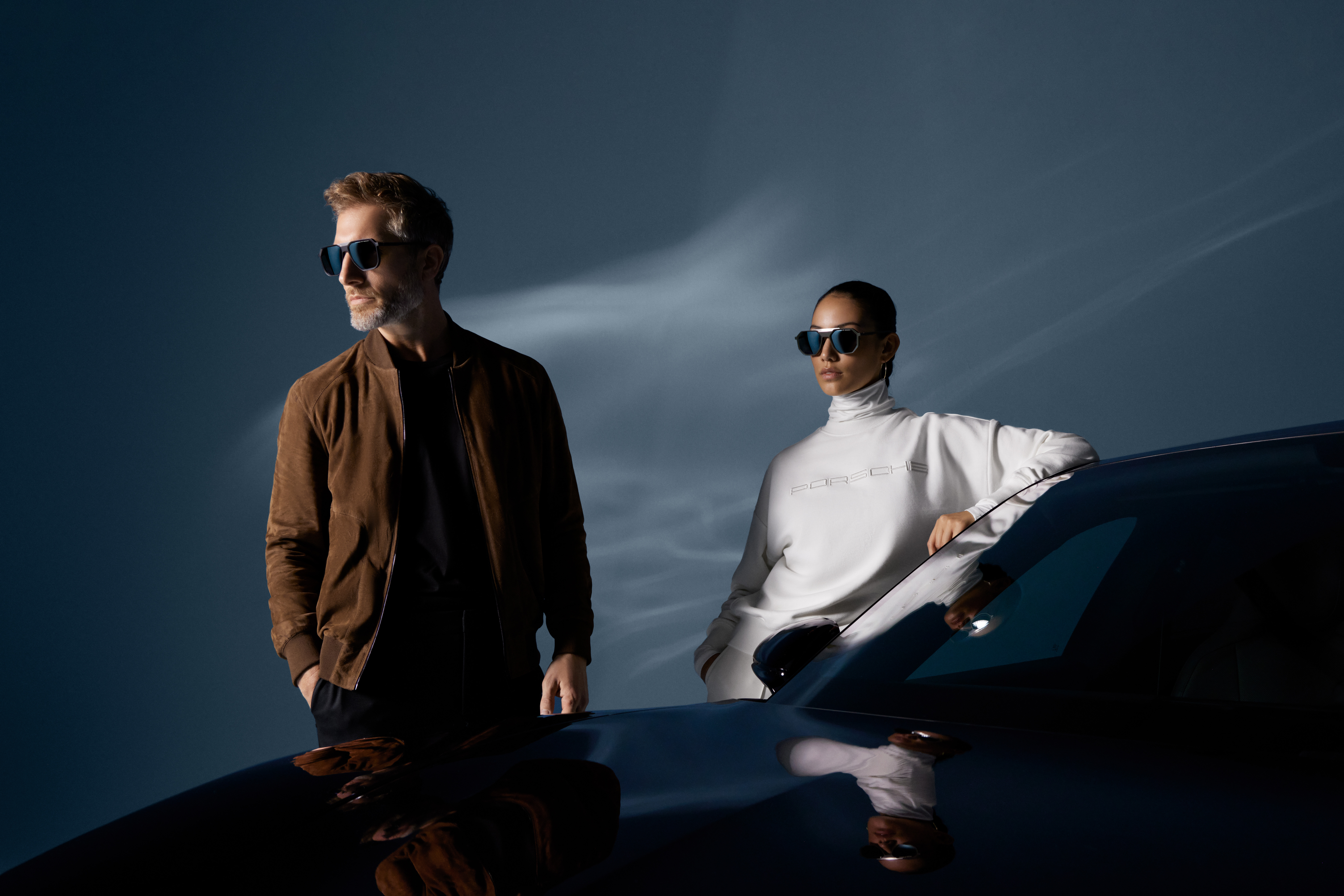 Shows Picture of man-and-woman-standing-next-to-porsche-car-wearing-porsche-design-fashion-v2.jpg