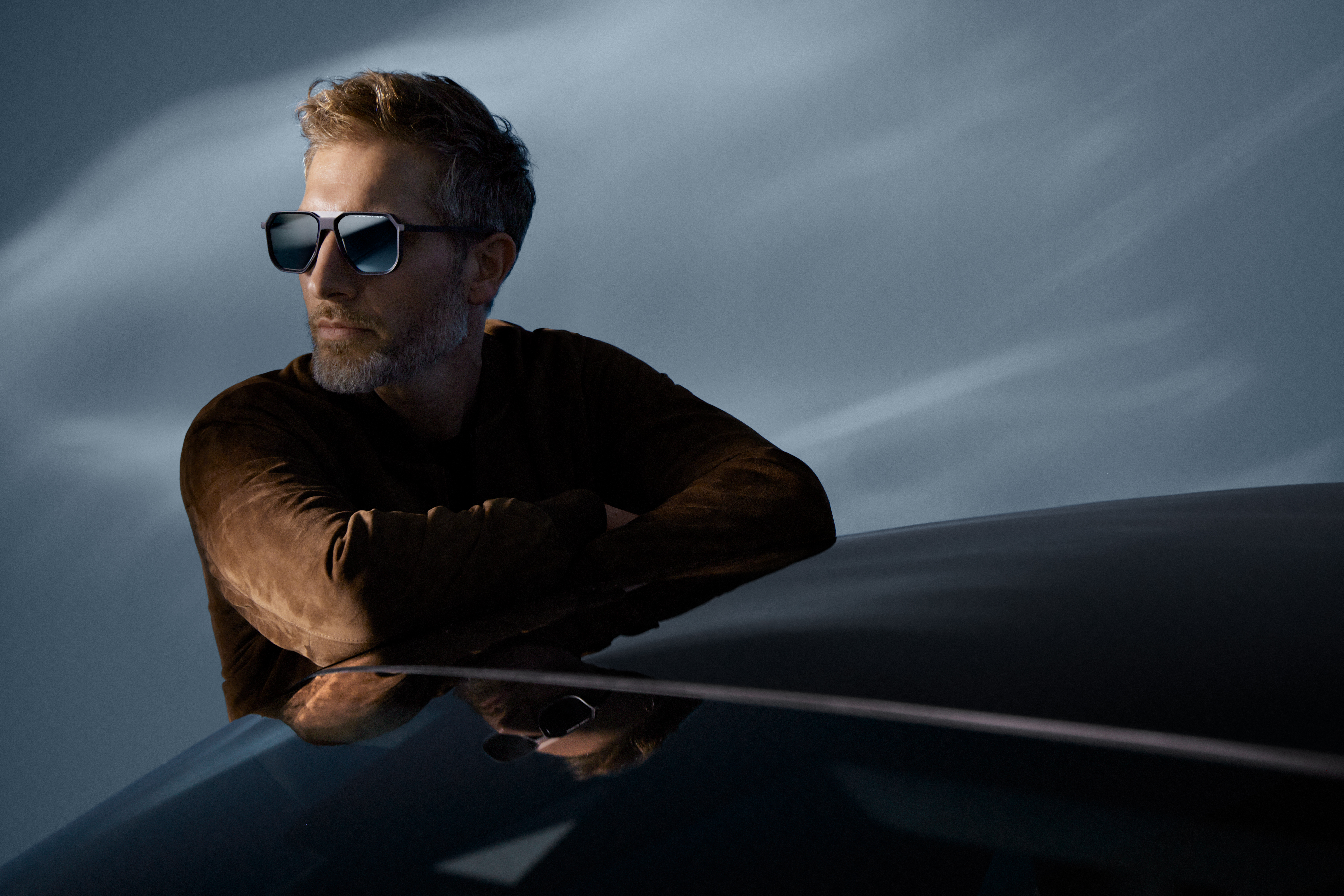 Shows Picture of man-leaning-on-car-wearing-leather-jacket-and-sunglasses.jpg